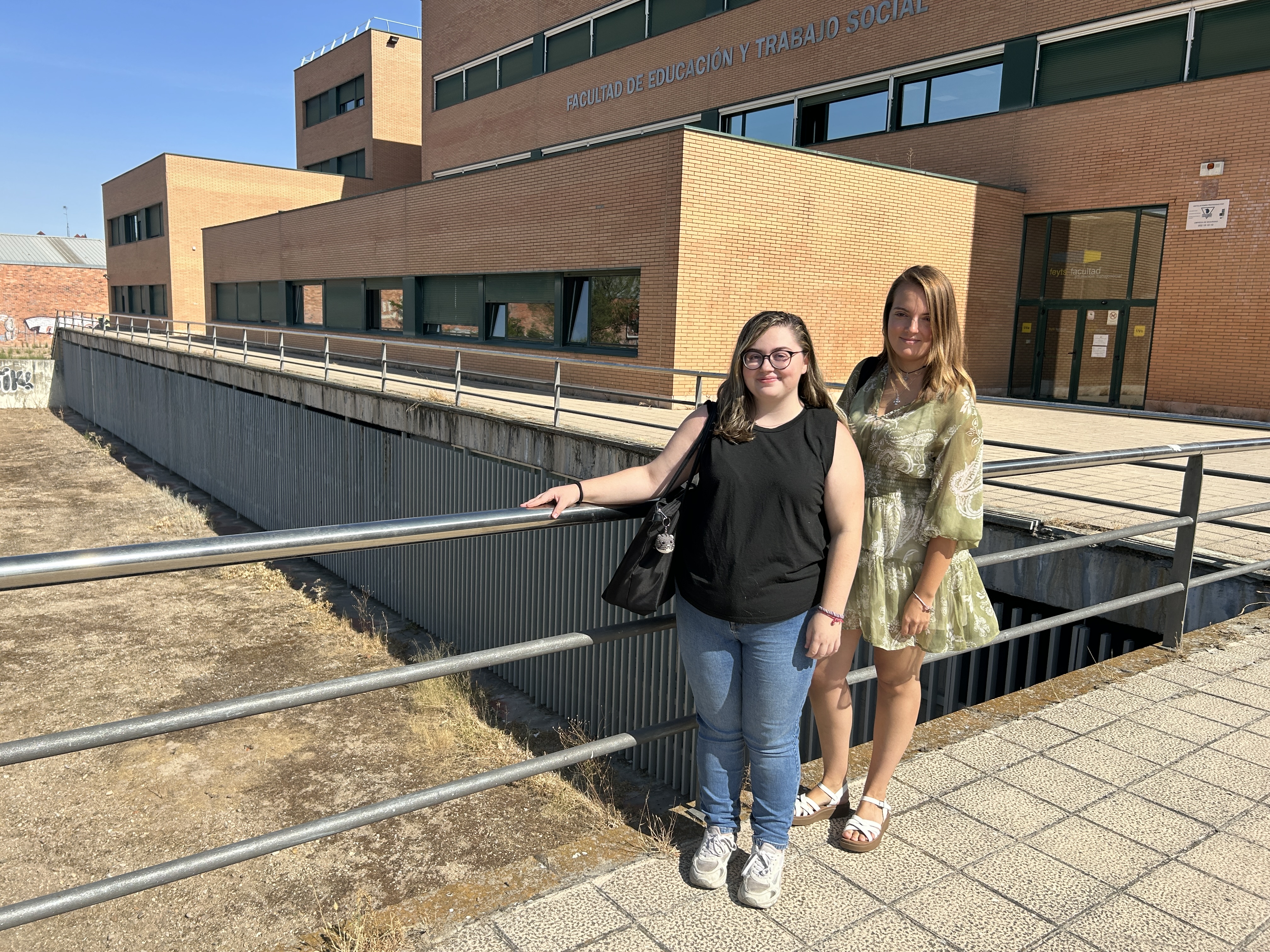 De izquierda a derecha: Gloria San José y Alba Betolaza, posan delante de la Facultad de Educación y Trabajo Social