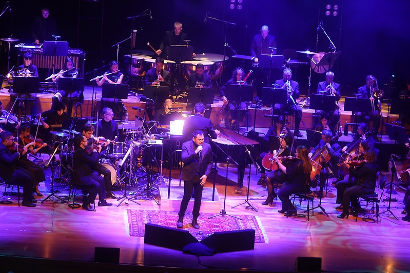 El cantante Ismael Serrano durante su actuación, acompañado de los músicos de la Orquesta de la Universidad de Valladolid
