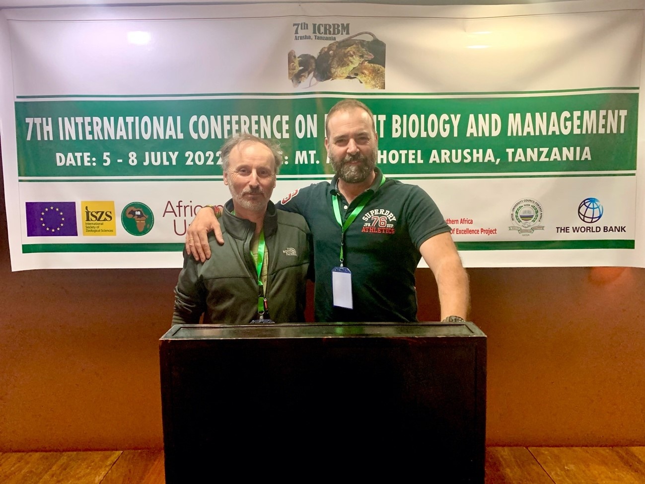 Los investigadores Juan José Luque-Larena, ETSIIAA-UVA (a la derecha), y François Mougeot, CSIC-IREC, posan ante uno de los carteles del 7ICRBM, celebrado en Arusha, Tanzania, entre los pasados 5 y 8 de julio. Foto: Hadas Hawlena