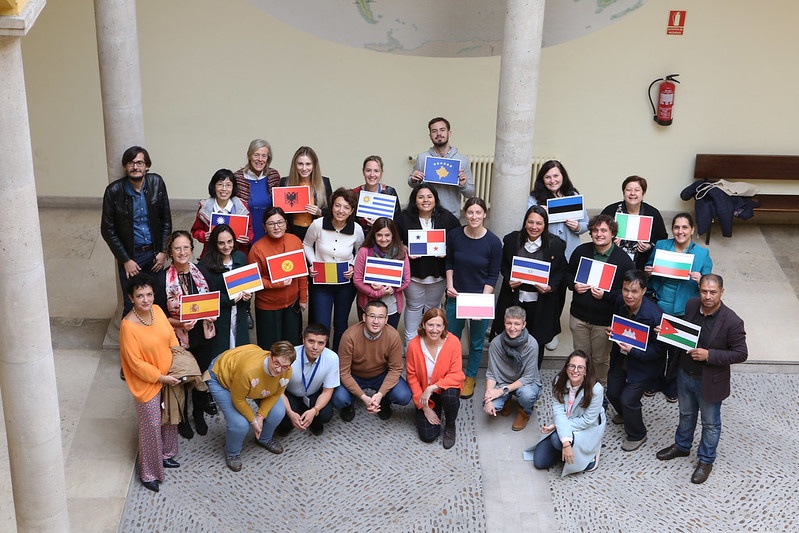 Foto de familia de los participantes junto a la vicerrectora de Internacionalización, Paloma Castro, que posa con la bandera española