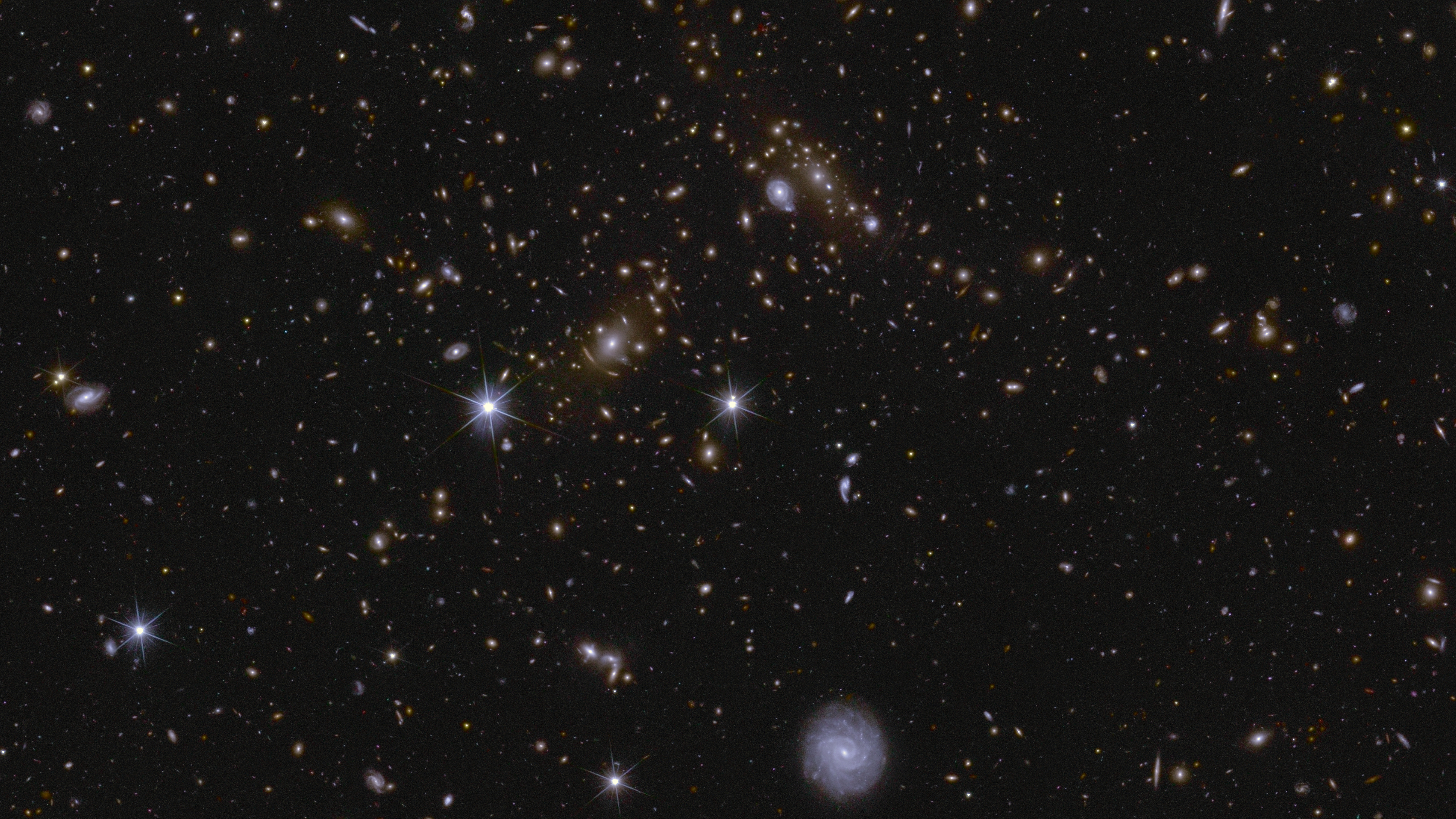 Esta imagen muestra una zona del Campo Profundo Sur de Euclides. El área está ampliada 70 veces en comparación con el mosaico grande. En esta imagen se aprecian varios cúmulos de galaxias enormes, así como luz intracúmulo y lentes gravitacionales. El cúmulo cercano al centro se denomina J041110.98-481939.3 y se encuentra a casi 6.000 millones de años luz de distancia. Imagen: ESA/Euclid/Euclid Consortium/NASA, image processing by J.-C. Cuillandre, E. Bertin, G. Anselmi
